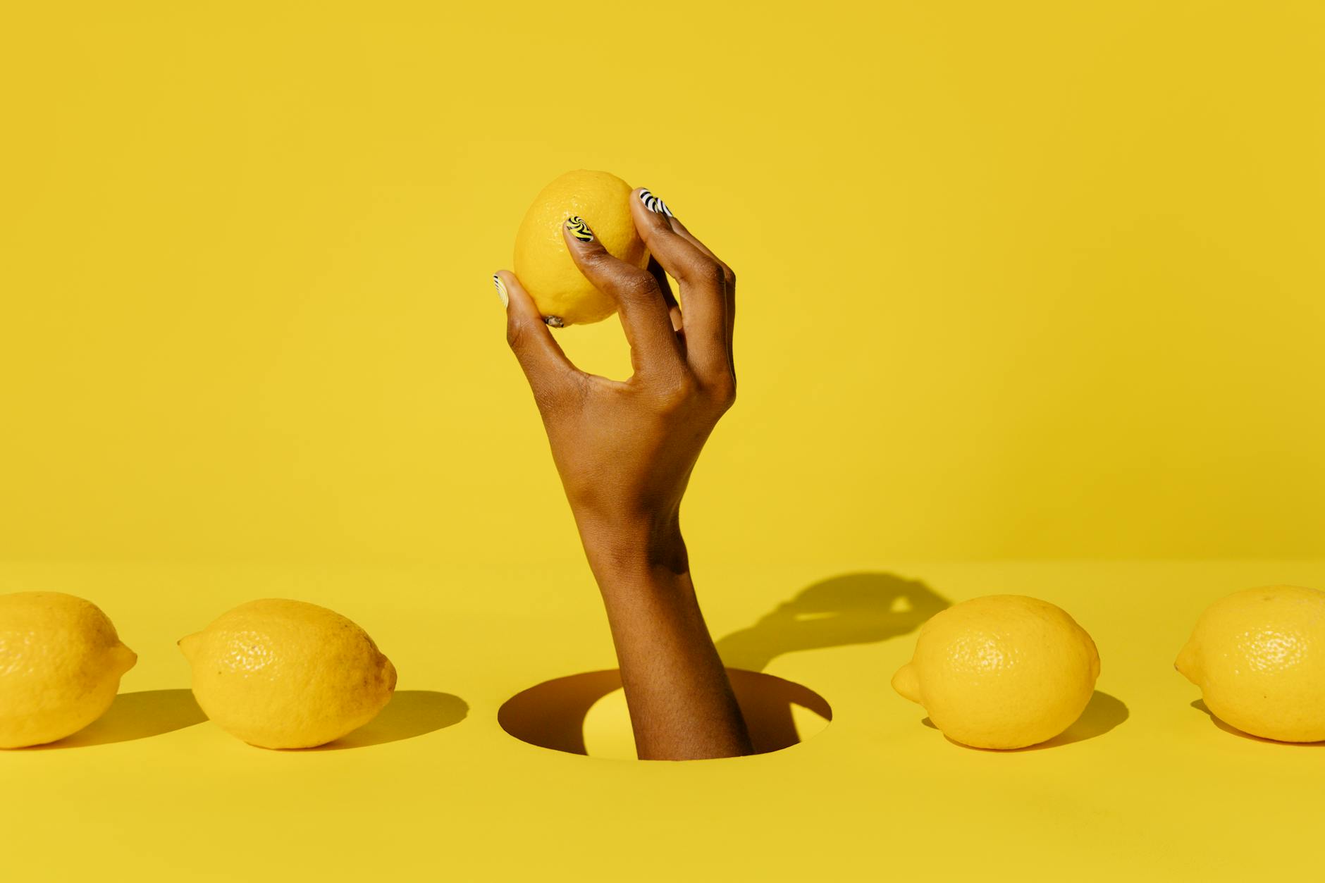 Two hands holding pink and blue silicone vibrators against a pastel background, representing intimate connection and self-pleasure