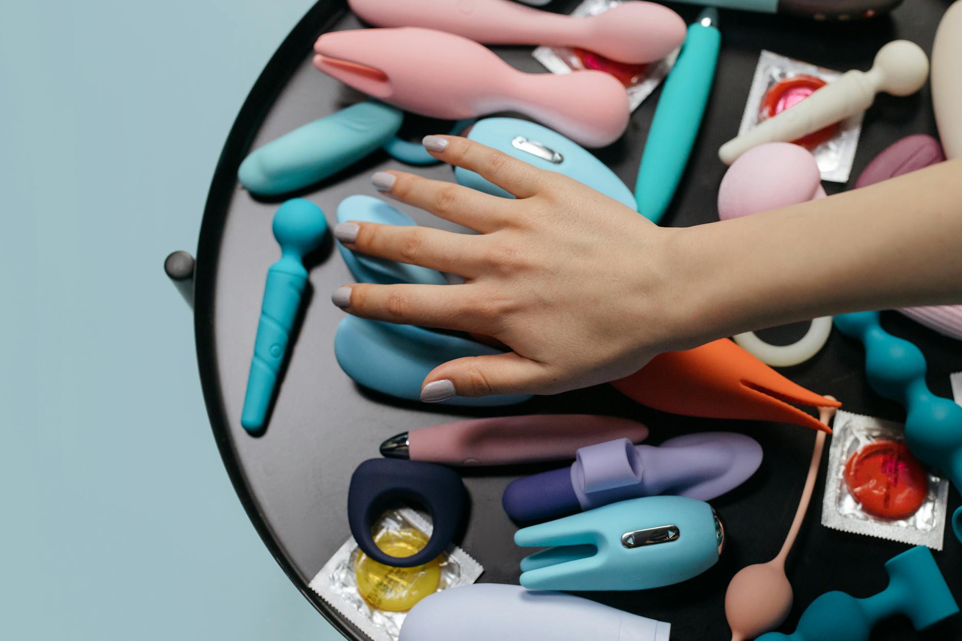 Close-up of diverse colorful sex toys displayed on a table, showing personal wellness choices.